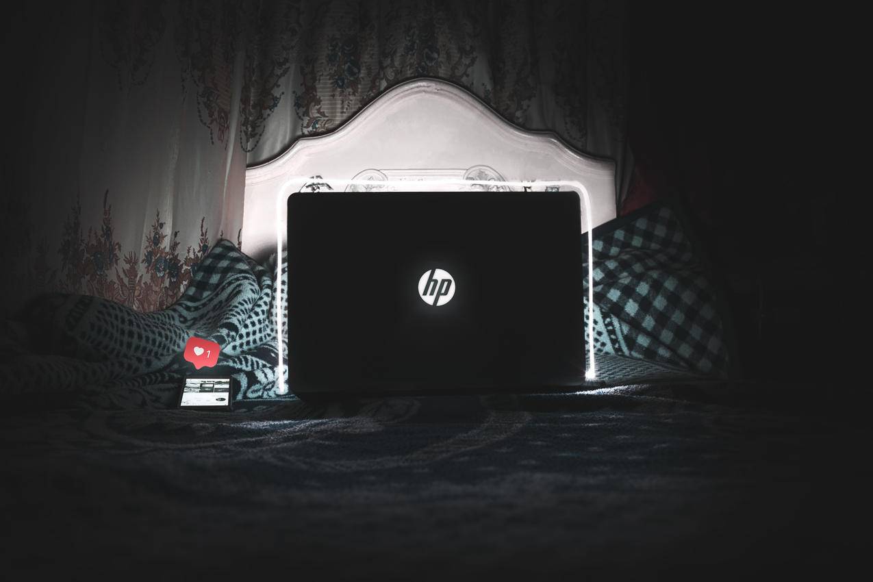 黑色HP笔记本电脑在床上