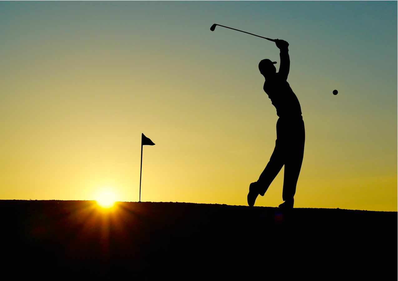日落时男子打高尔夫球的剪影