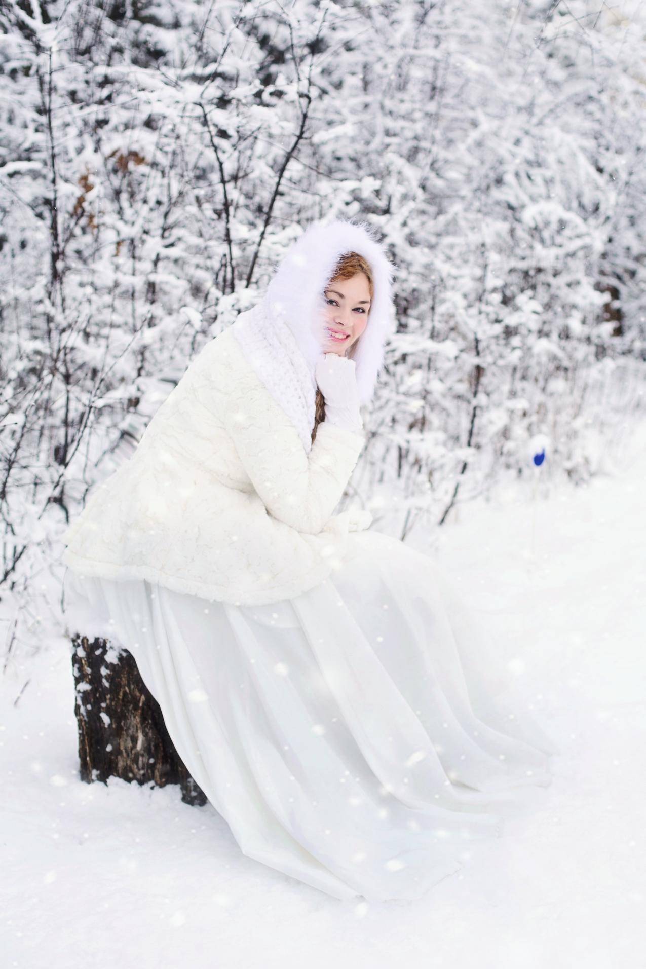 白色雪地里的白裘皮连衣裙里的女人