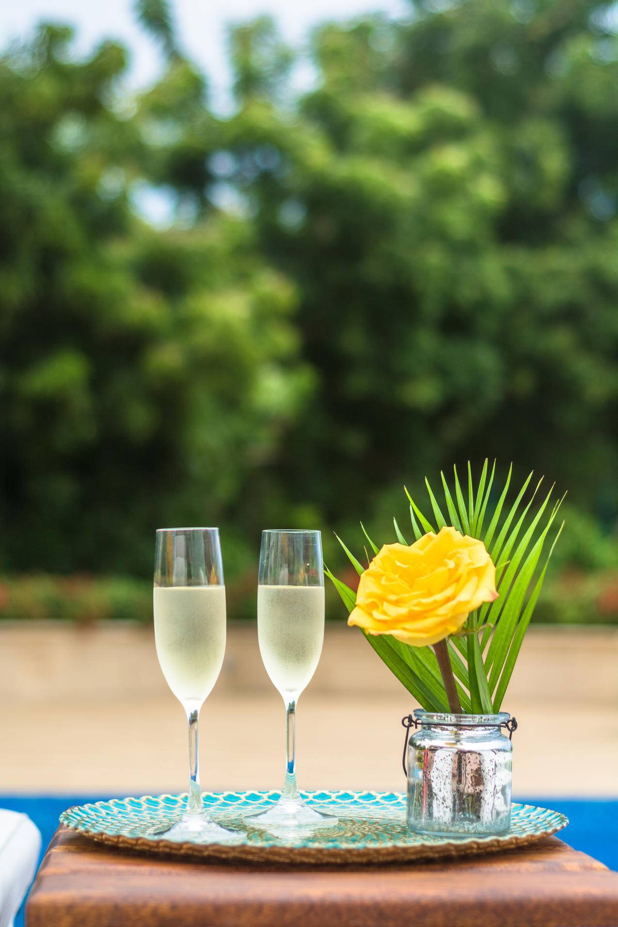 黄色玫瑰花中心和两个清澈的香槟长笛