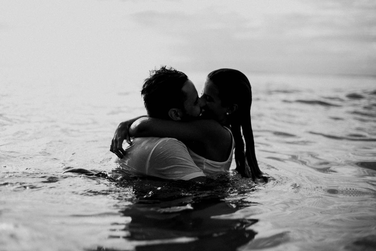 男人和女人站在岸边接吻 · 免费素材图片