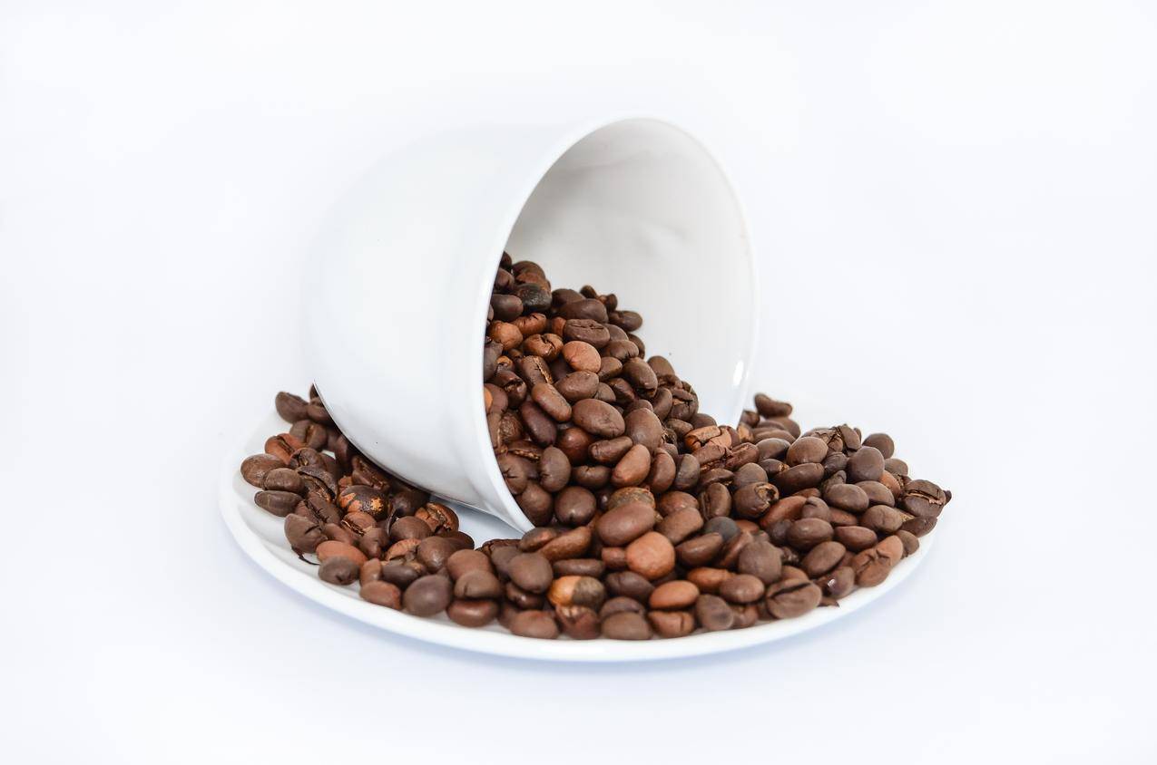白色陶瓷茶碟上的咖啡豆