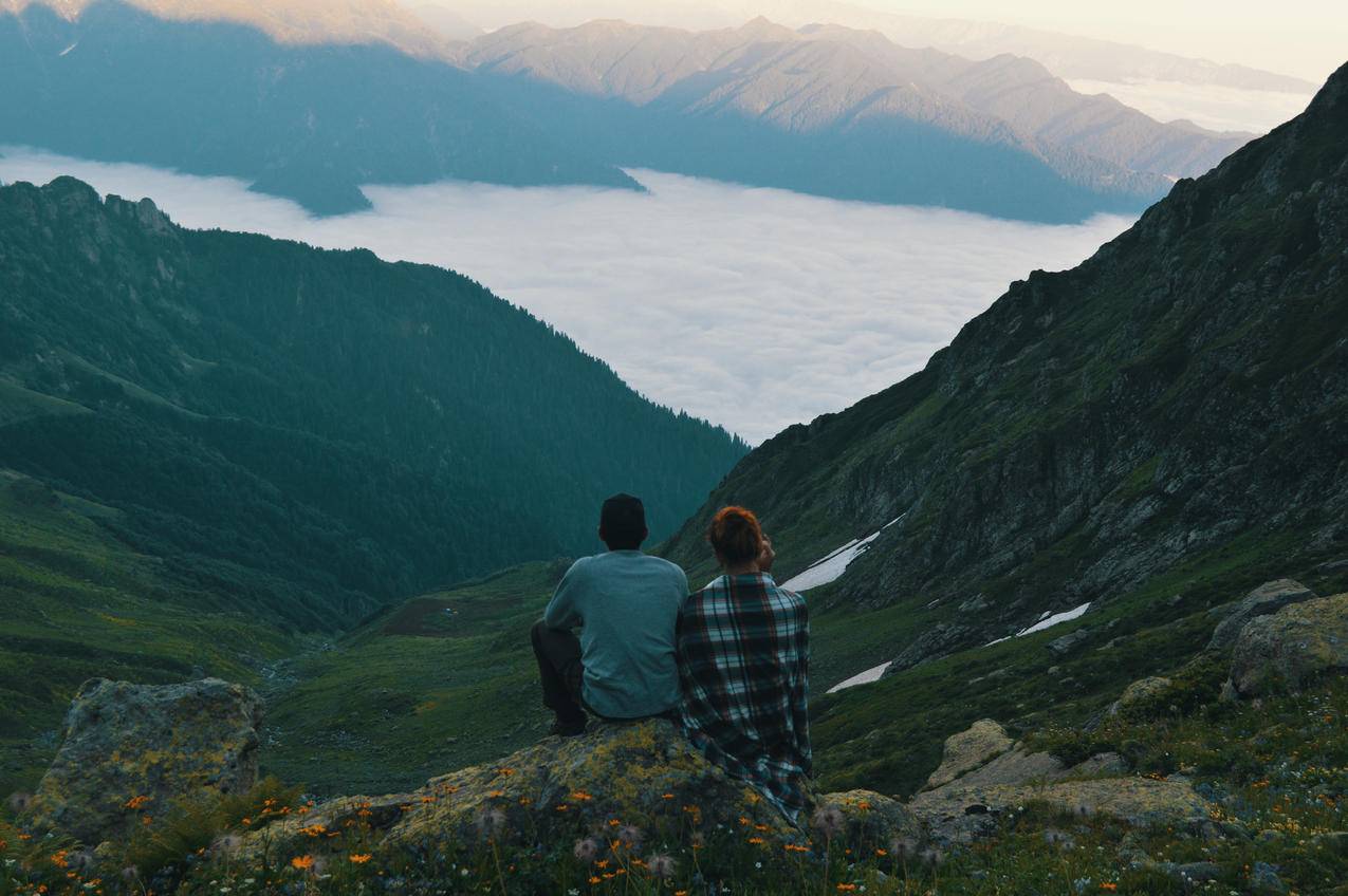 坐在山峰边的两个人