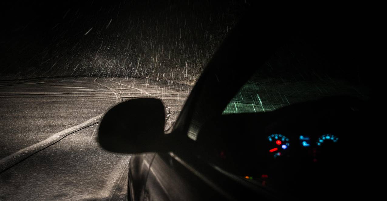 夜间下雨时路面上的黑色车