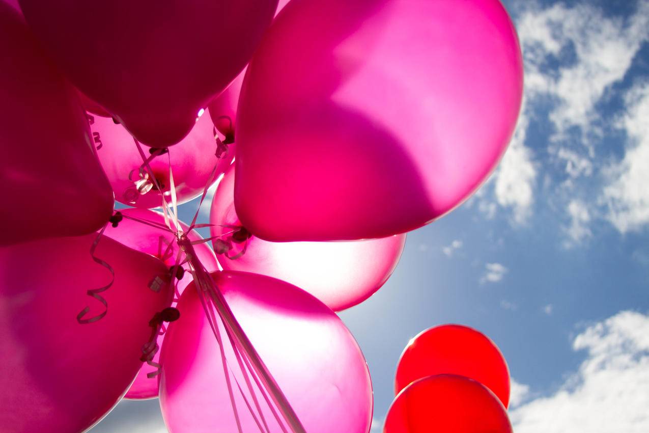 白天的粉红色气球和红色气球