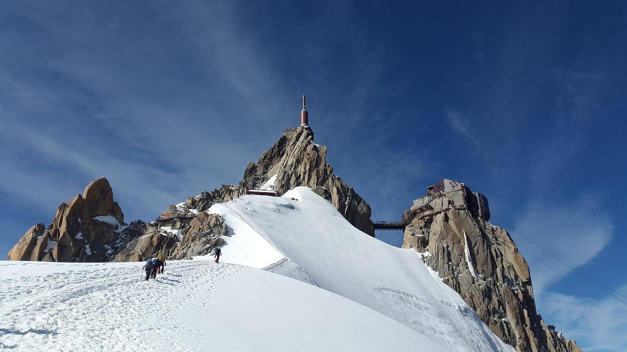 白天,人们在雪地上向山顶走去