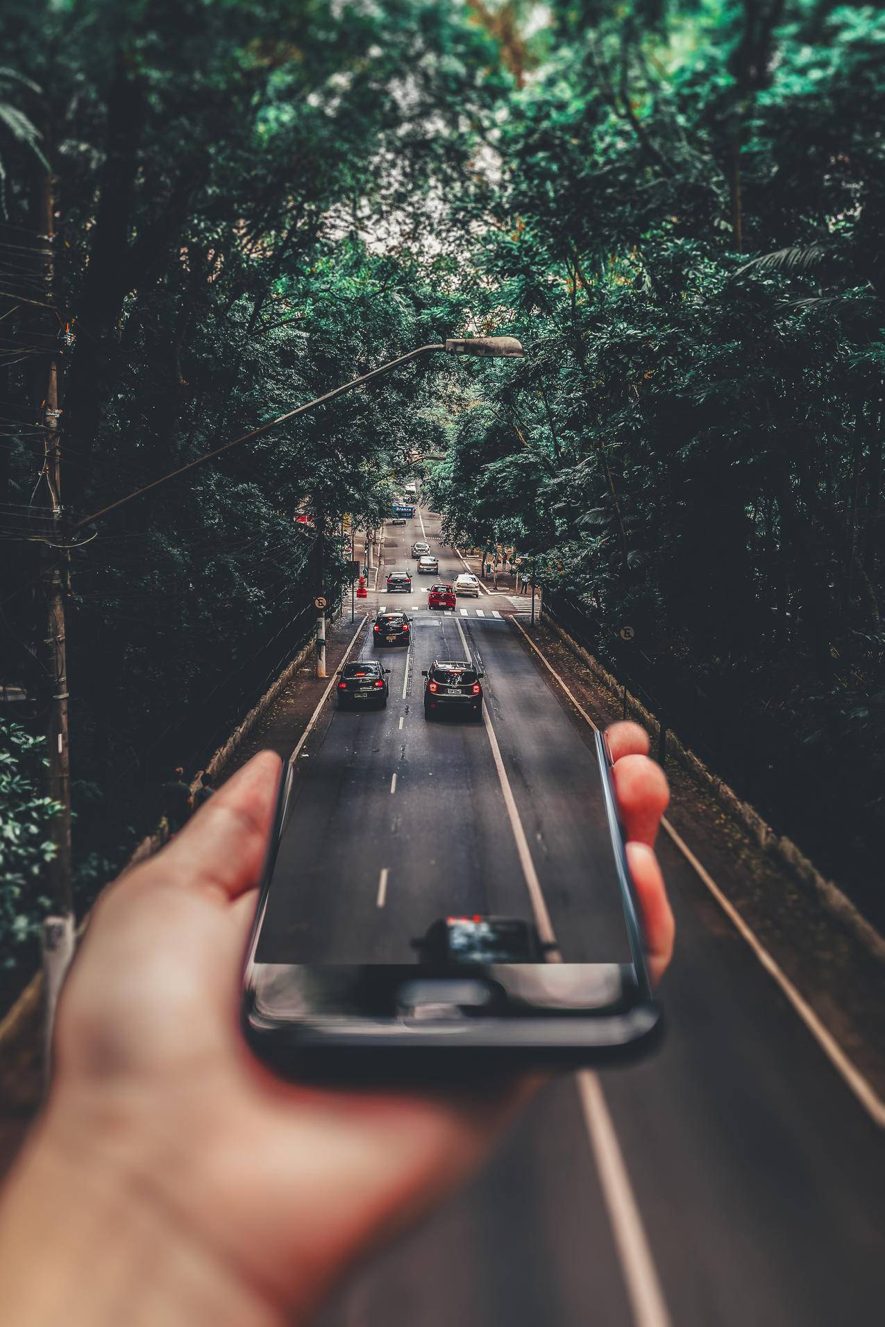 在智能手机下面行驶的汽车的强制透视摄影