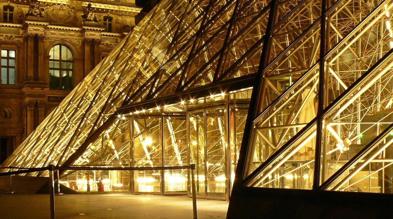Museum外的金属框玻璃金字塔夜间黄灯