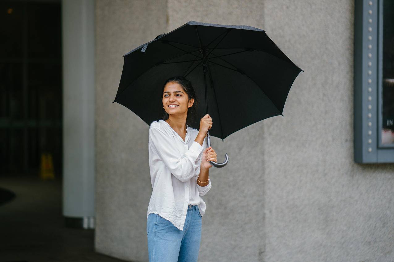 Woman,Wearing,White长袖衬衫和蓝色牛仔裤握黑色雨伞的照片