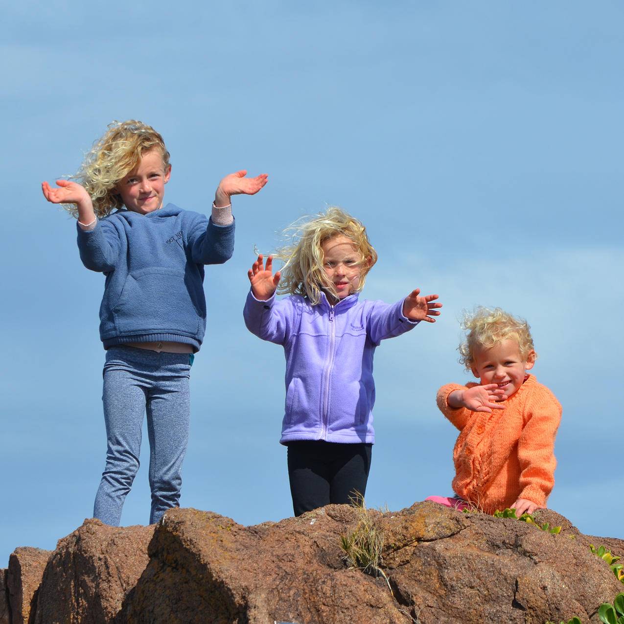 站在岩石上的3个孩子