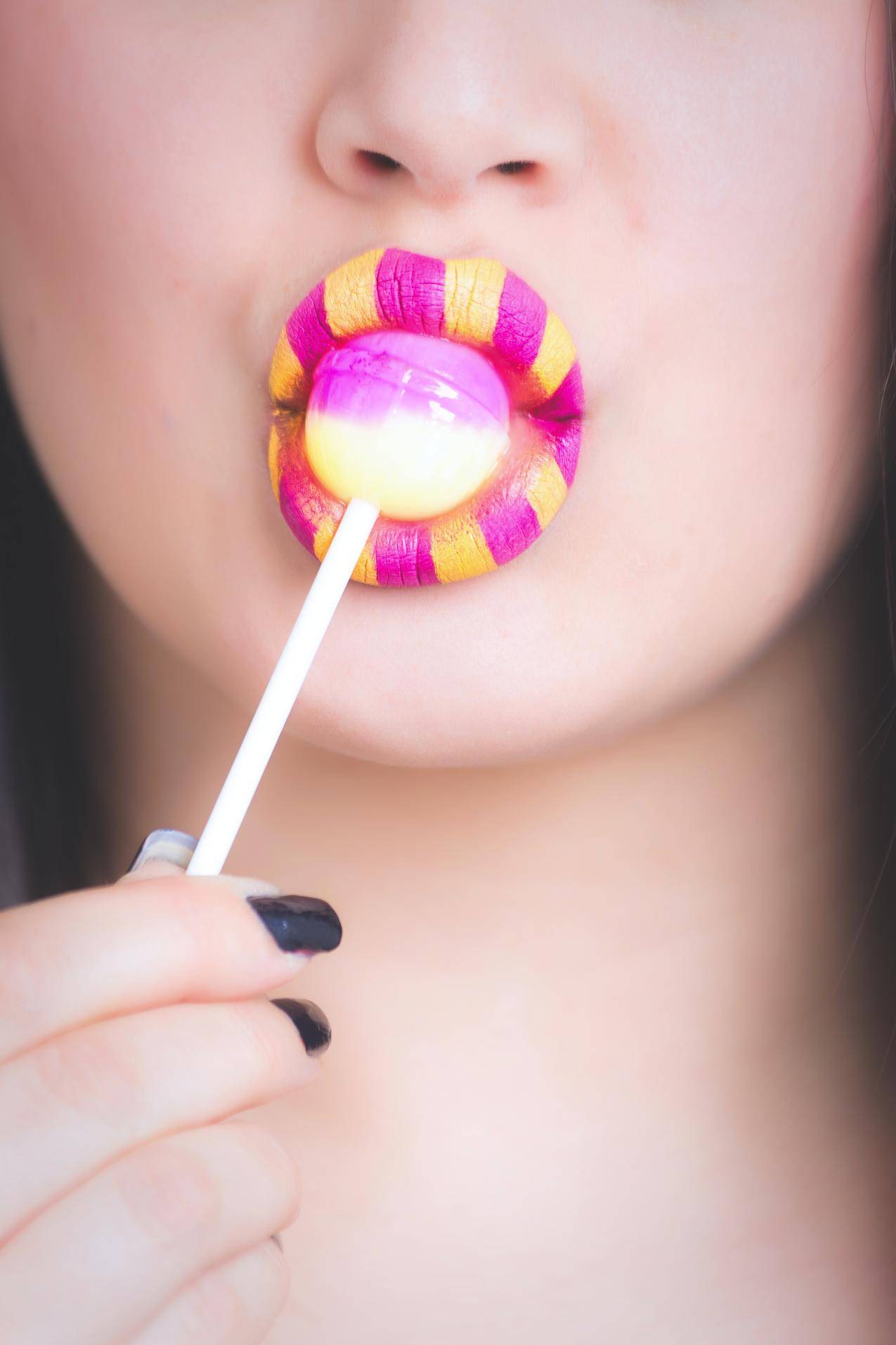 女人舔粉红色和White,Lollipop