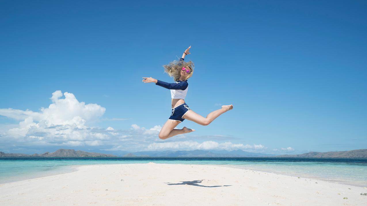 海滩跳跃的青春少女图片