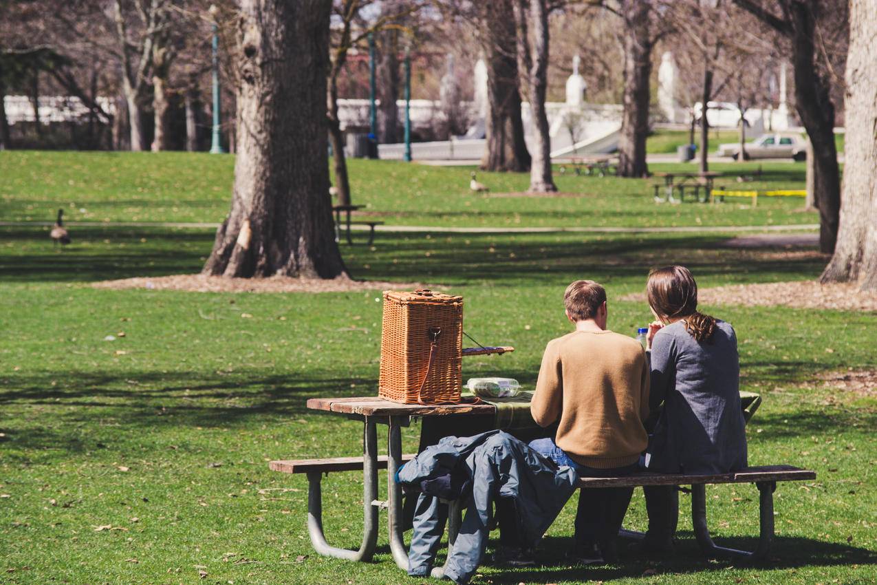 坐在棕色木制野餐桌上的男人和女人