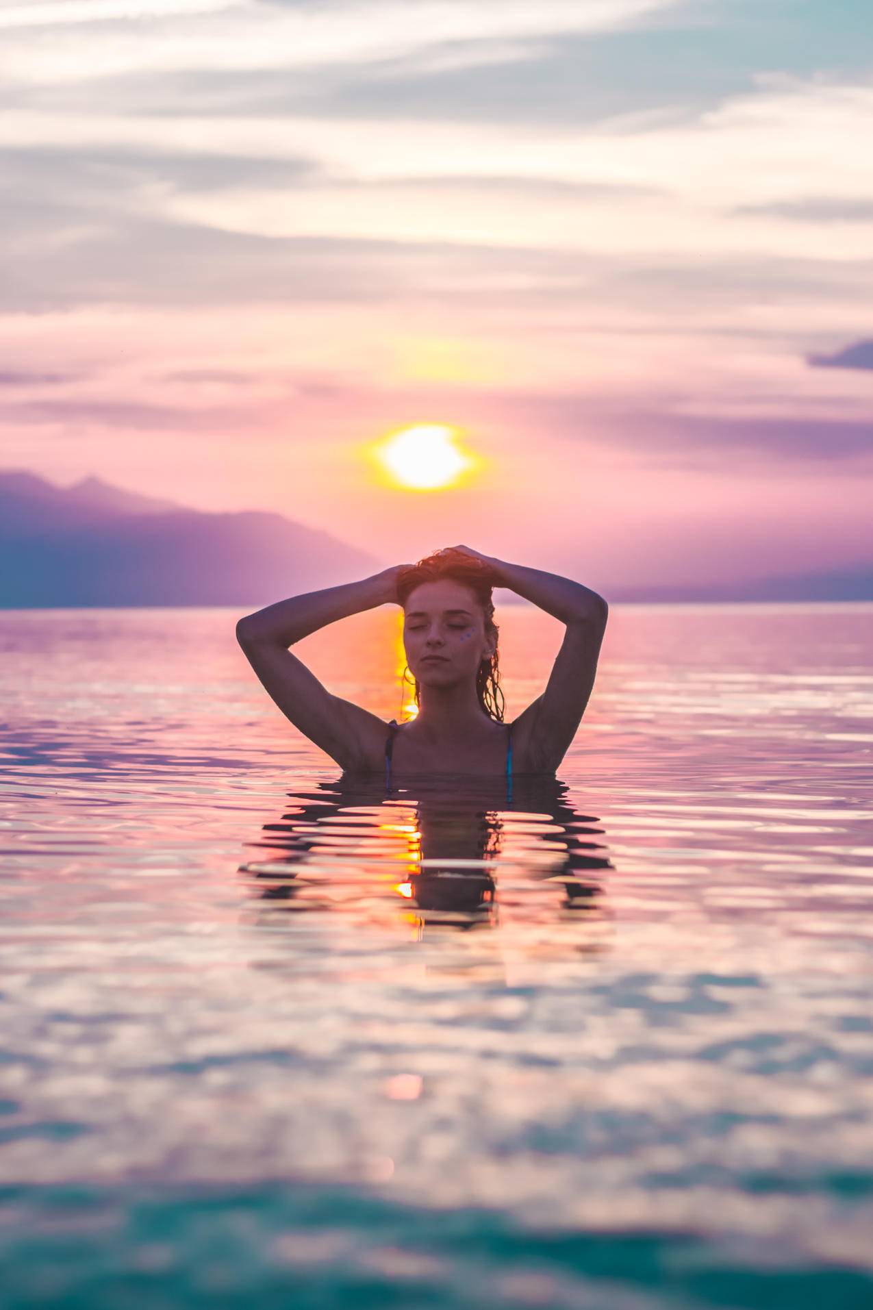 黄金时段沐浴在水中的女人的选择性焦点高清图片
