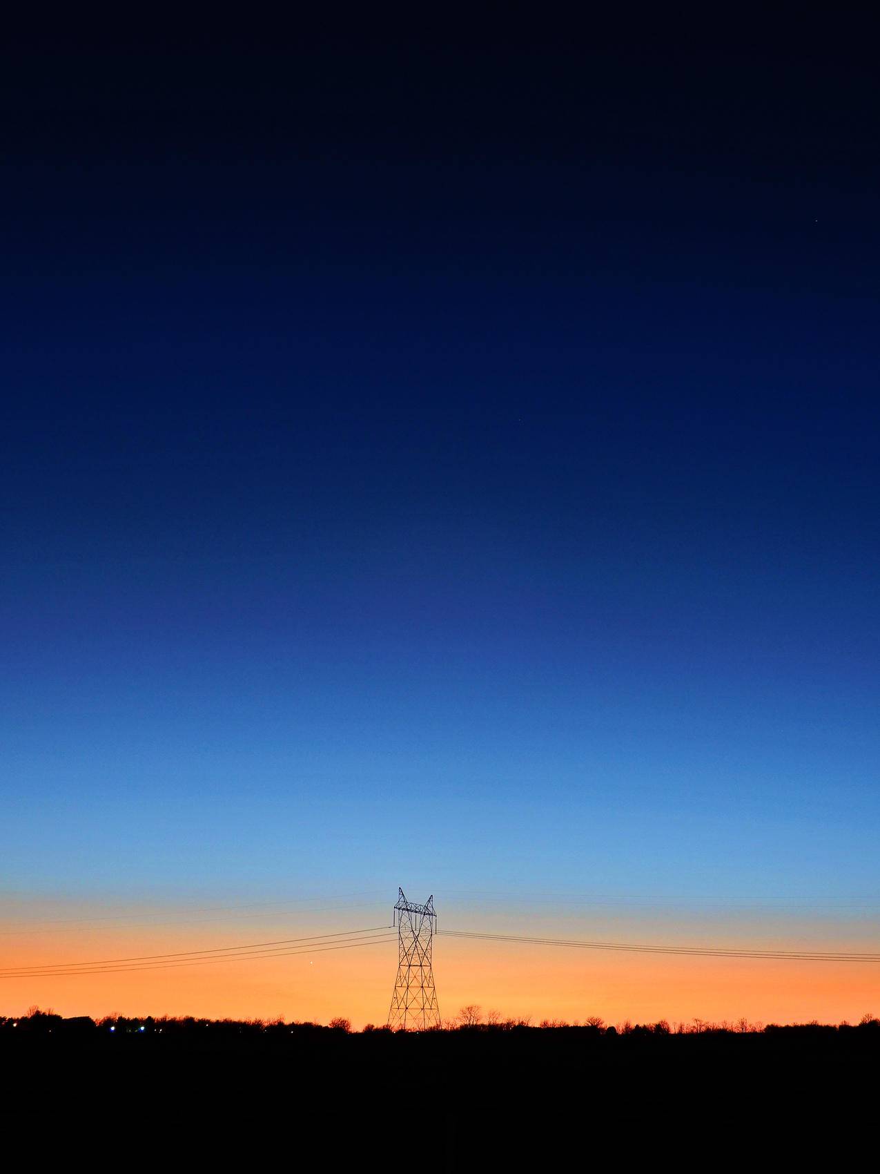 蓝橙色天空下的黑色发射塔