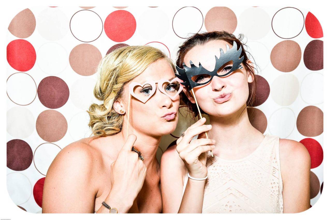 两个女人在照相馆拍照留住黑色和粉红色伪装面具