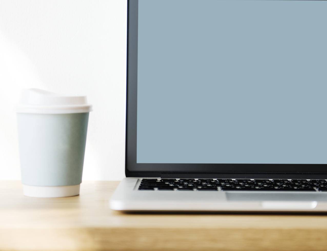 棕色木表面灰色一次性杯子旁的MacBook,Pro