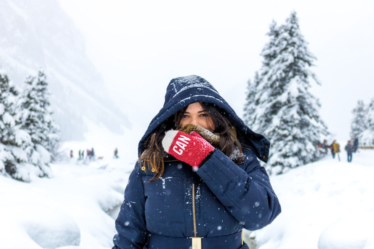 穿着蓝色拉链上衣的女人站在雪地上