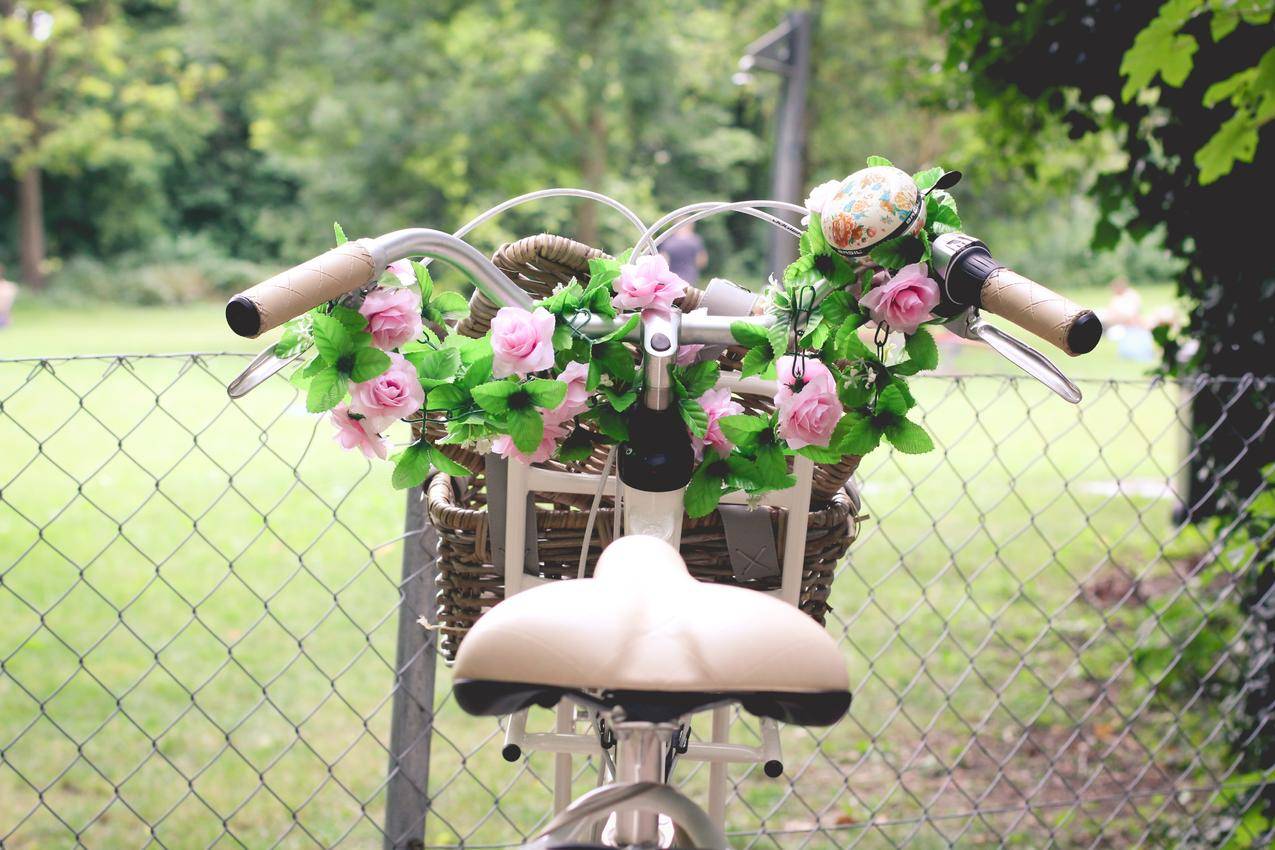 棕色自行车篮子里的粉红色玫瑰花束