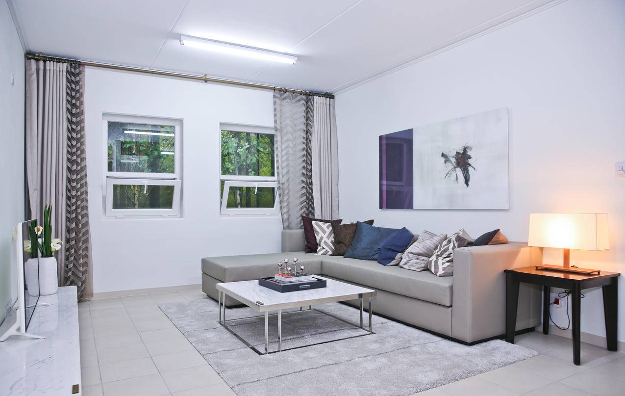 灰色的L型沙发和白色客厅的各种彩色枕头