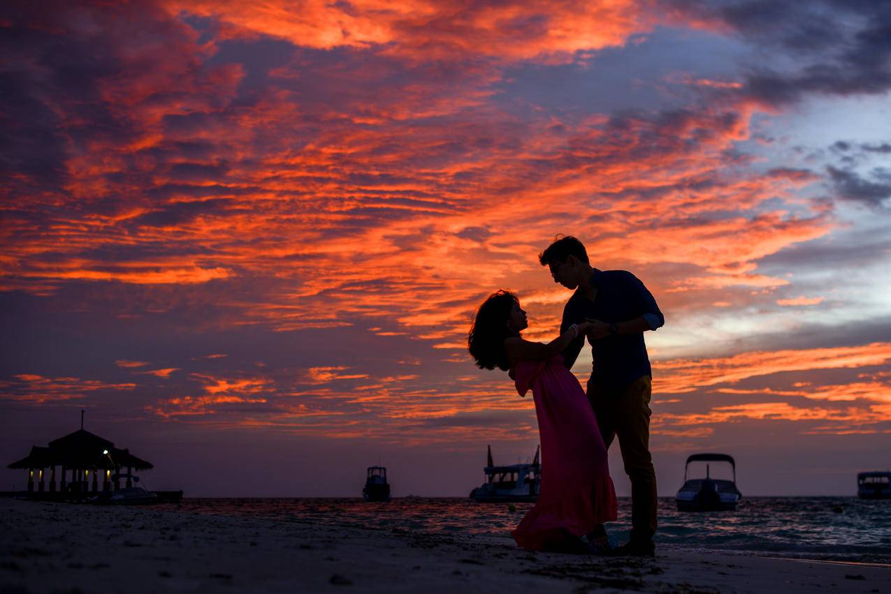 日落时海滩上的男人和女人