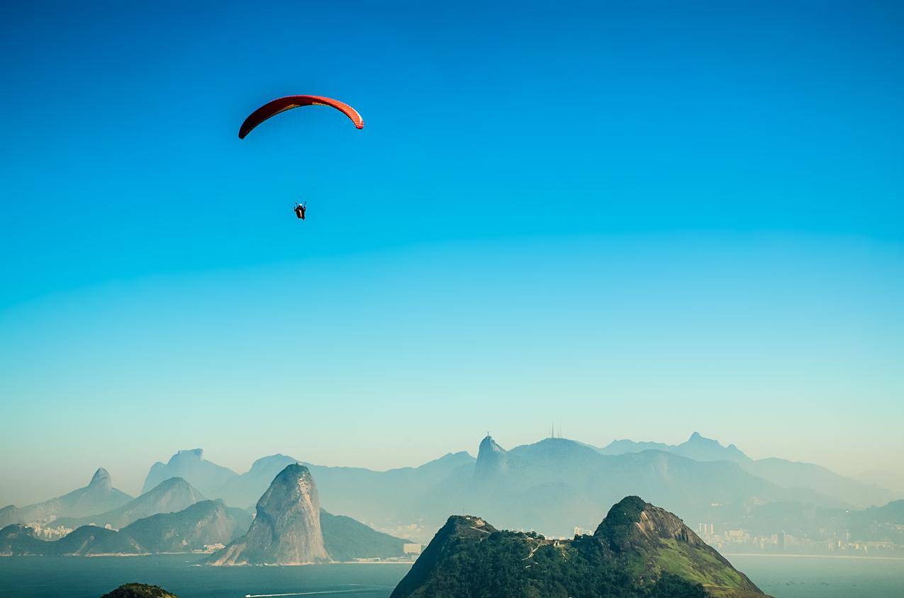 一个人白天在火山湖上空跳伞的全景图片