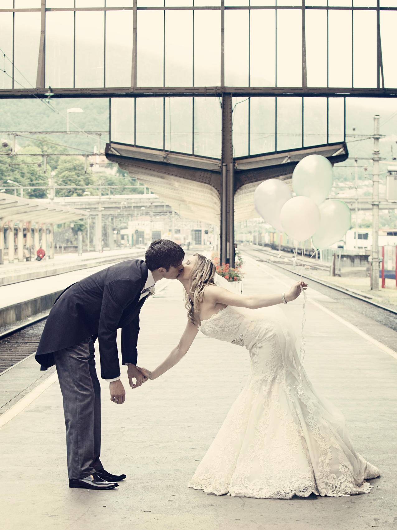 夫妻亲吻站在火车等待平台上