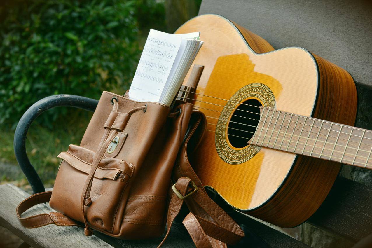 棕色木制板凳旁棕色皮革桶旁边的棕色声吉他