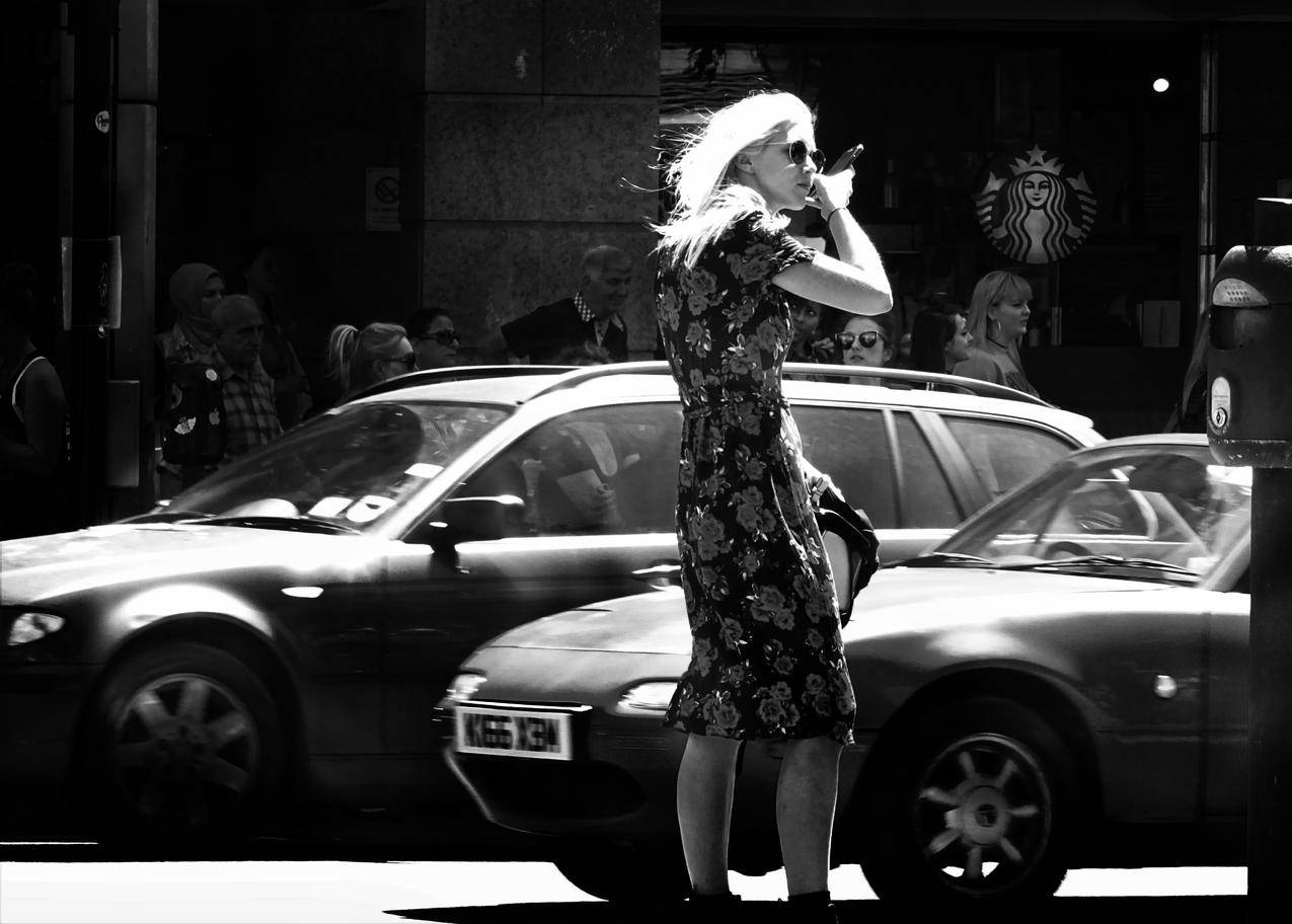 女士穿着花卉短袖礼服站在汽车旁的灰阶高清图片