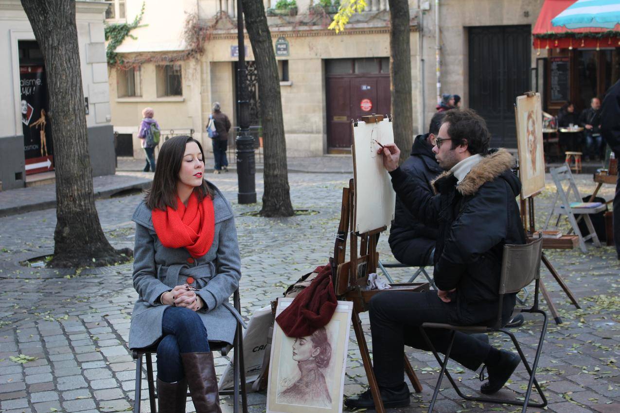 街头卖艺的画家写生与模特的图片