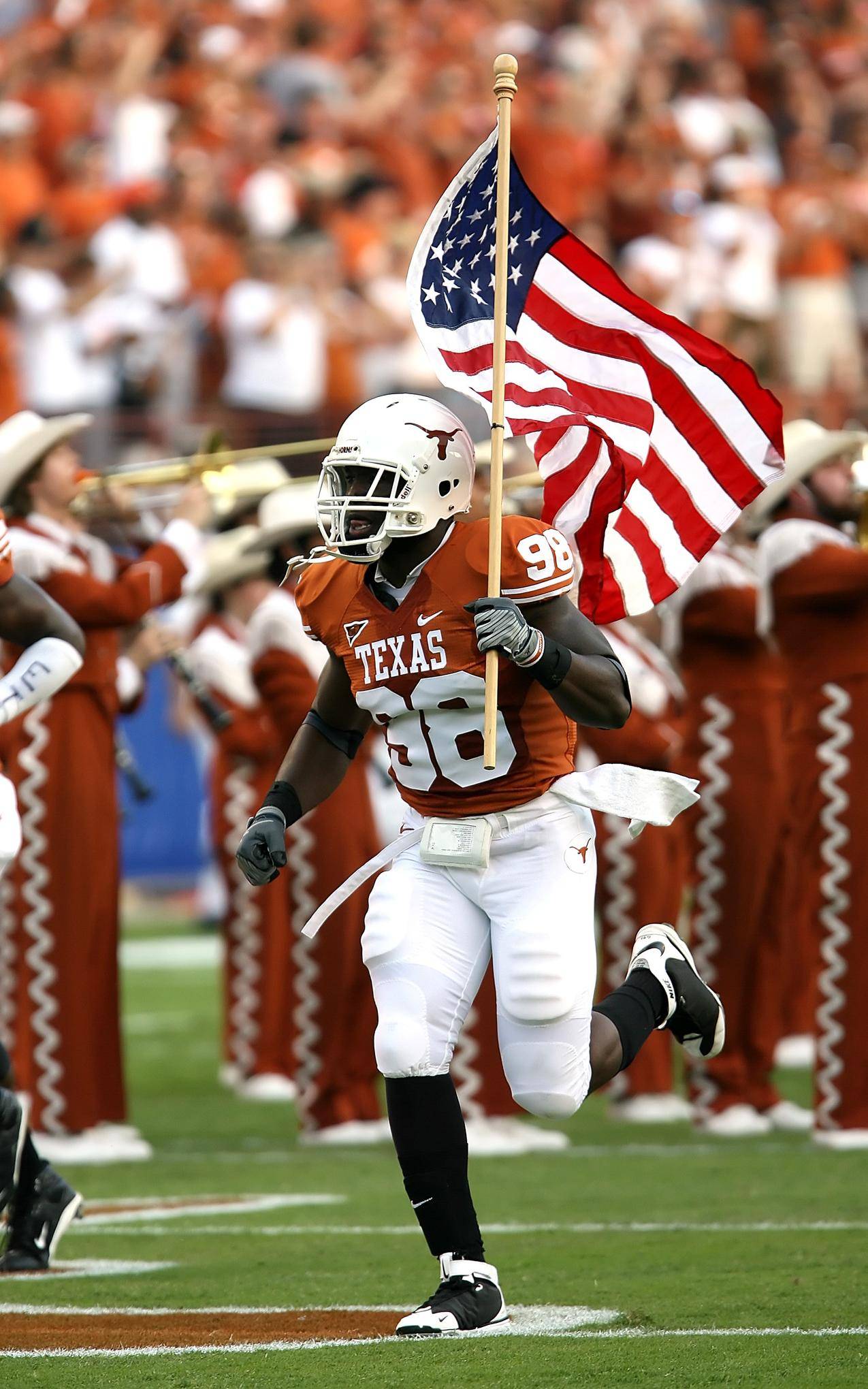 NFL球员在球场上拿着美国国旗