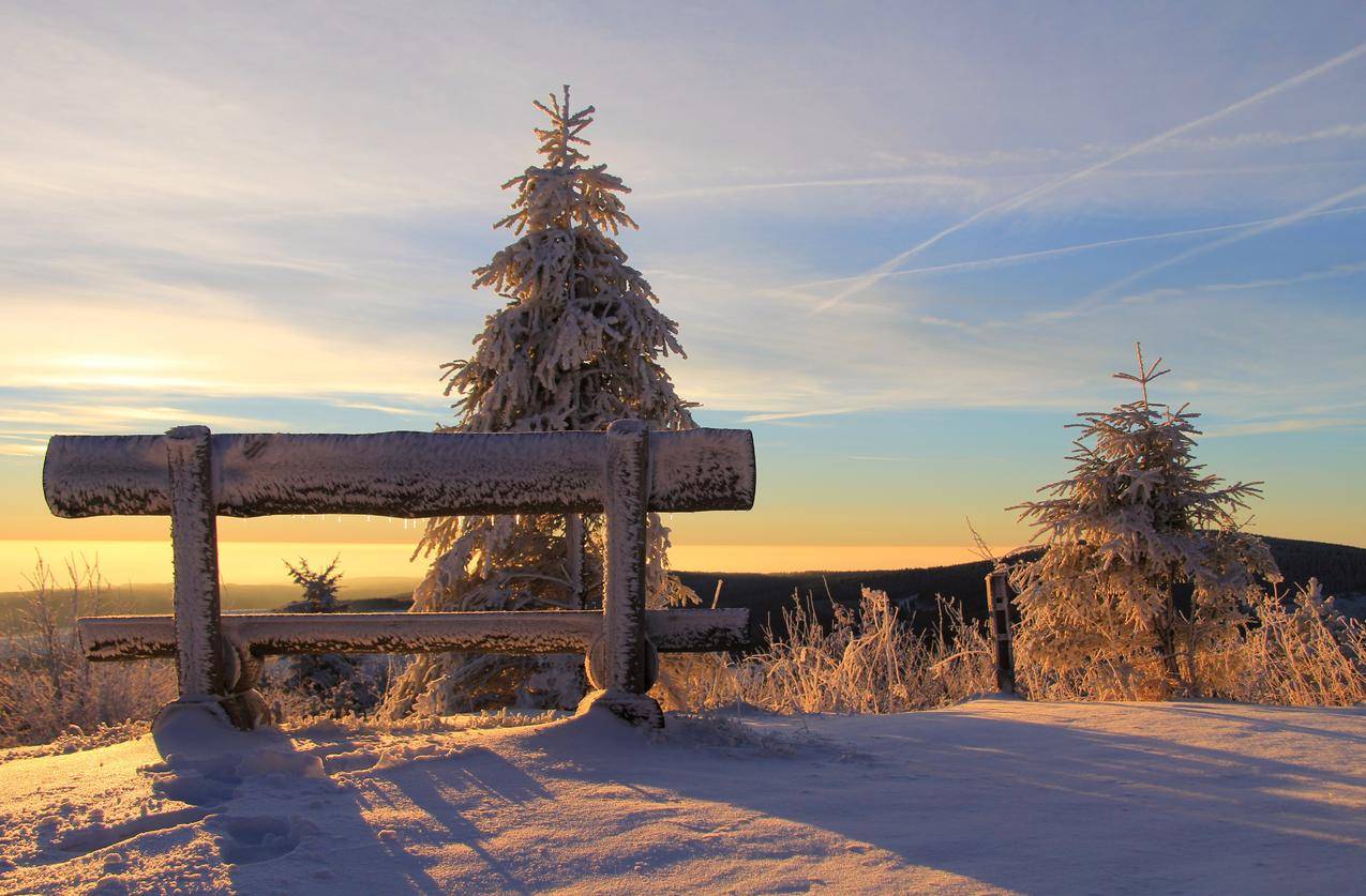 日落时山顶上的雪白长凳