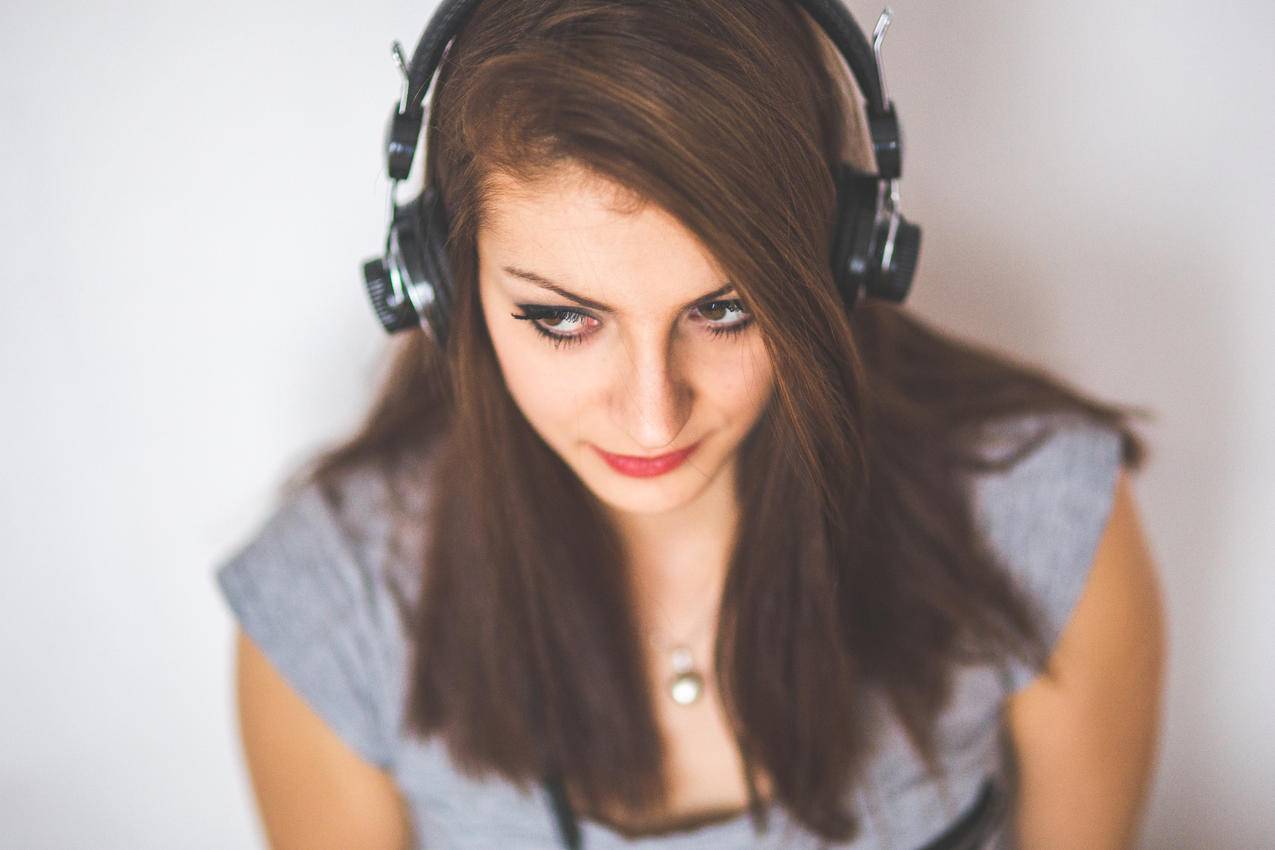 年轻漂亮女孩用耳机听音乐的肖像