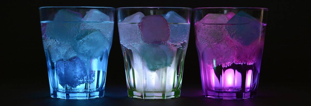 清澈的酒杯上加冰块的蓝白色和紫色饮料