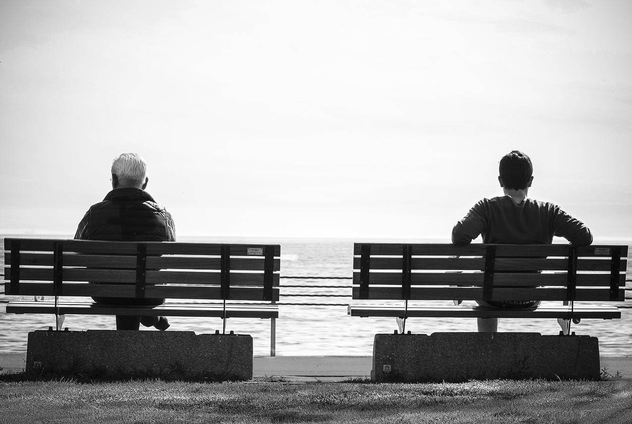灰阶照片2人坐在海边的长凳上