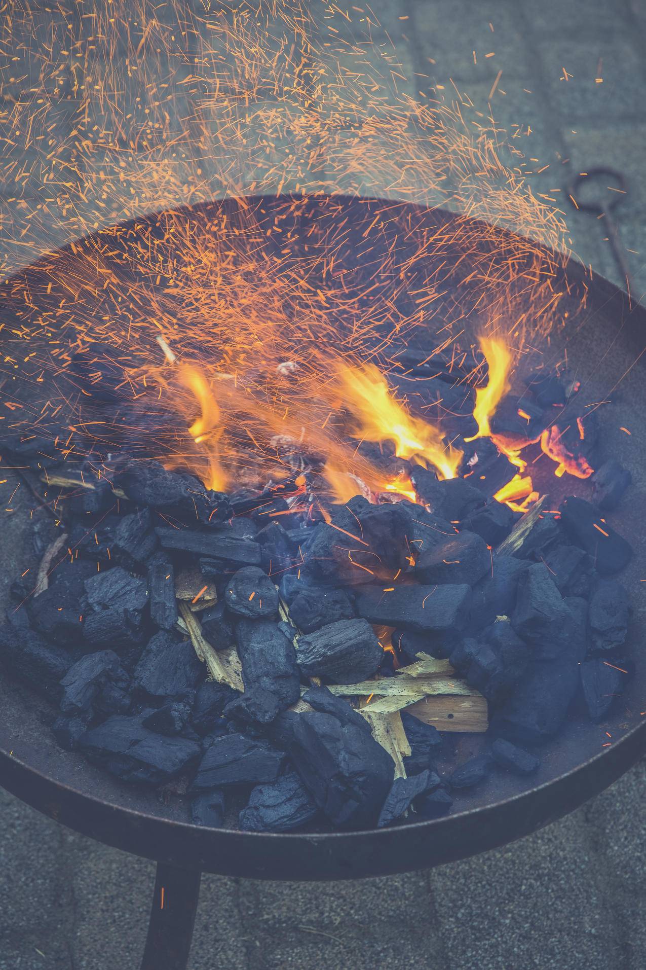 黑木炭火在黑圆钢碗上
