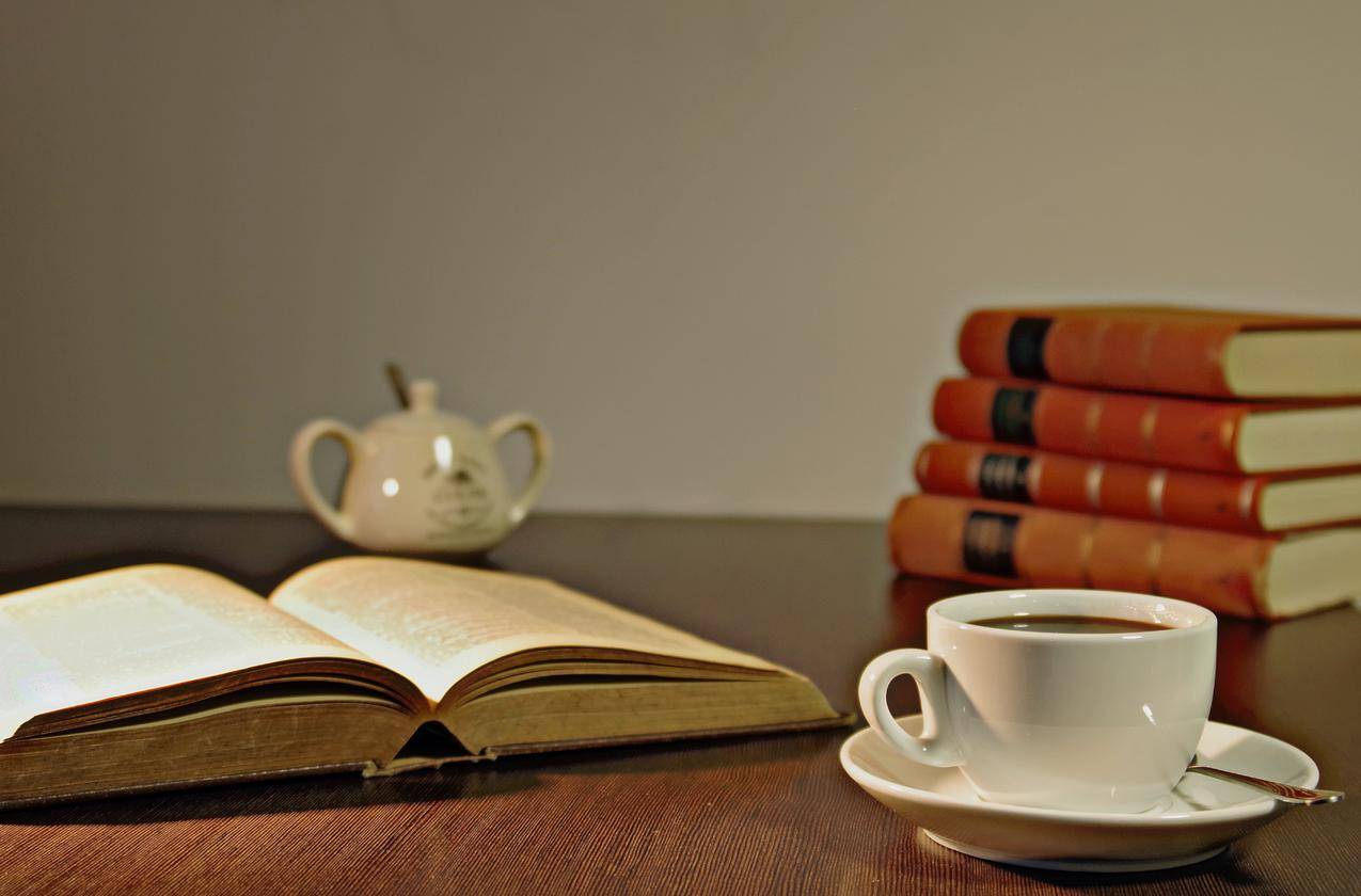 书桌旁的棕色木桌上的白色陶瓷茶杯