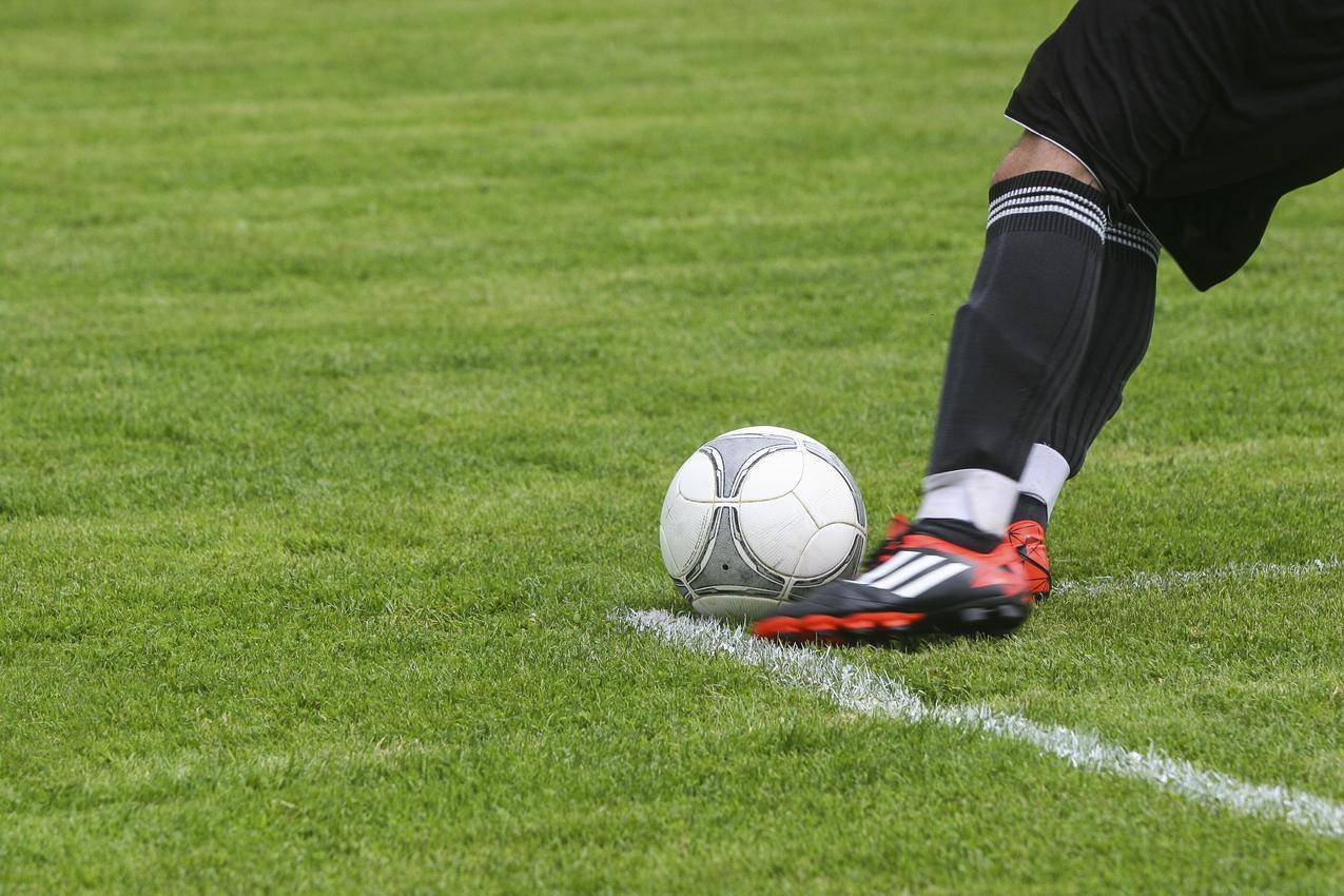 足球运动员在草地上踢白色灰色足球
