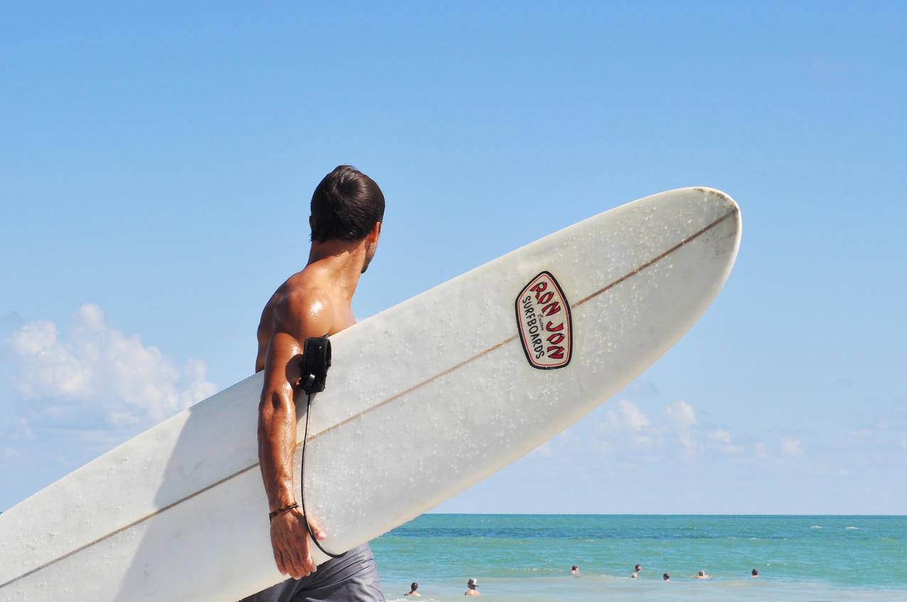 海边拿着冲浪板的男人人物图片
