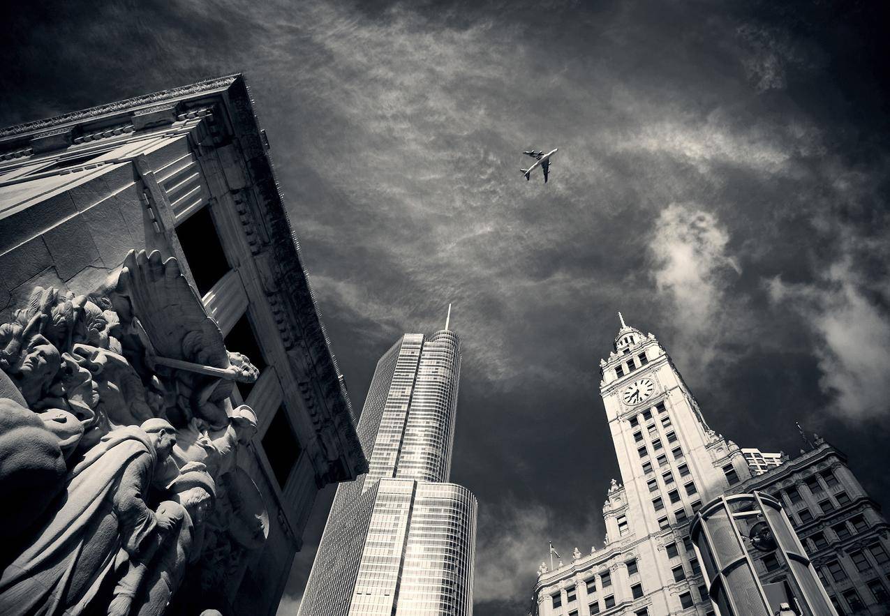 飞机在混凝土建筑物和雕像上的灰度摄影