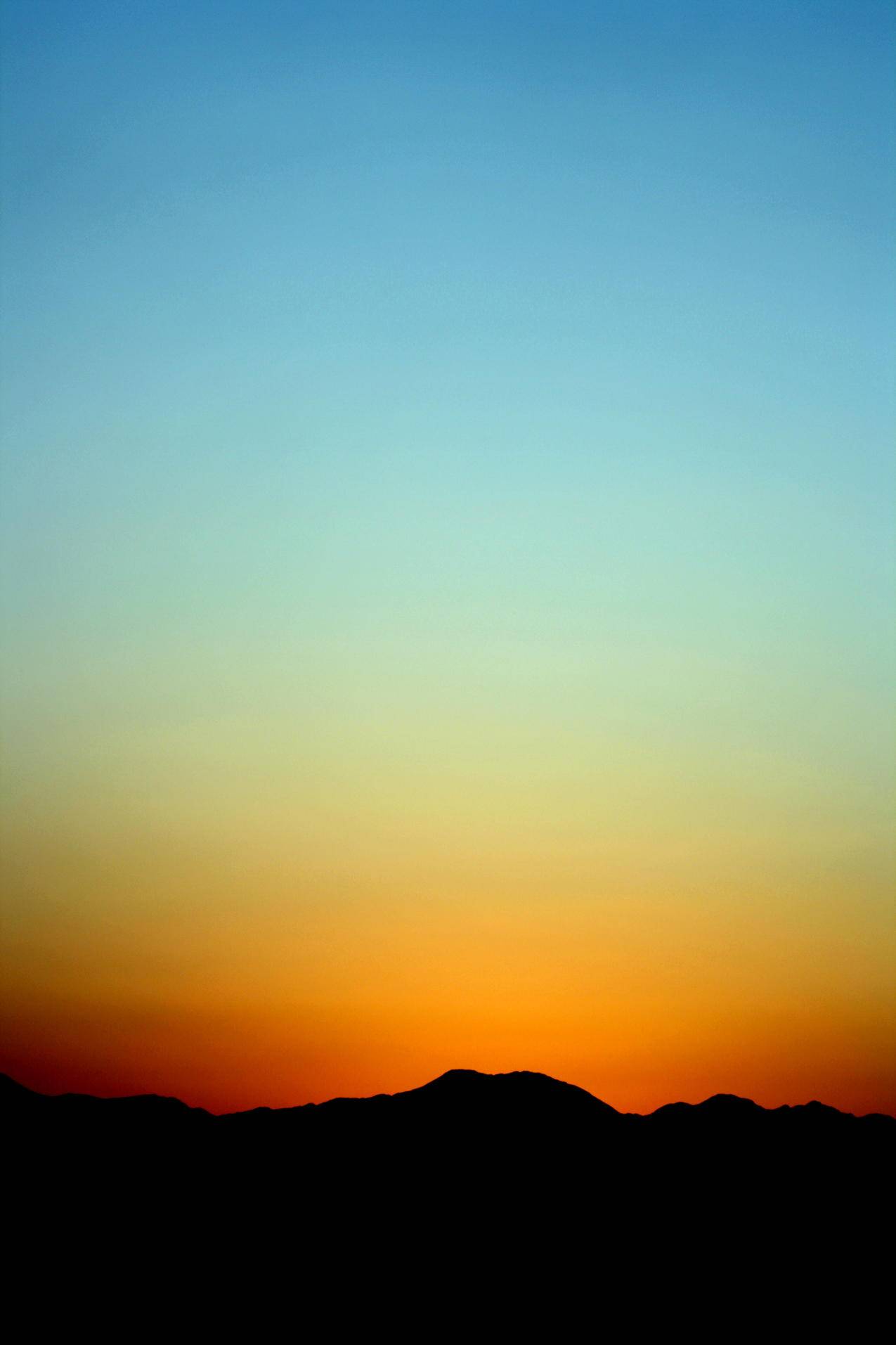 夕阳下橙色蓝天的山影