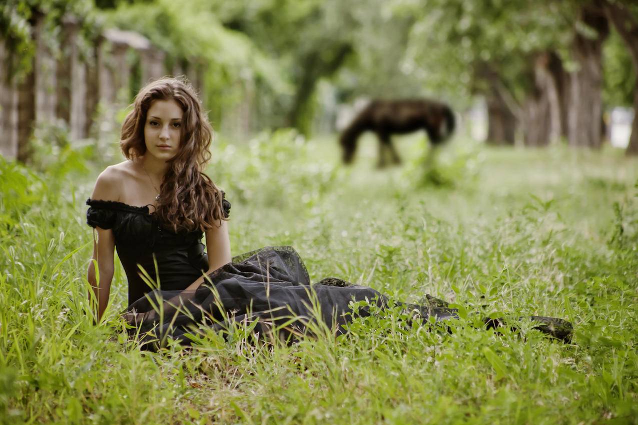 坐在草地上的美女,黑色裙子,4K壁纸