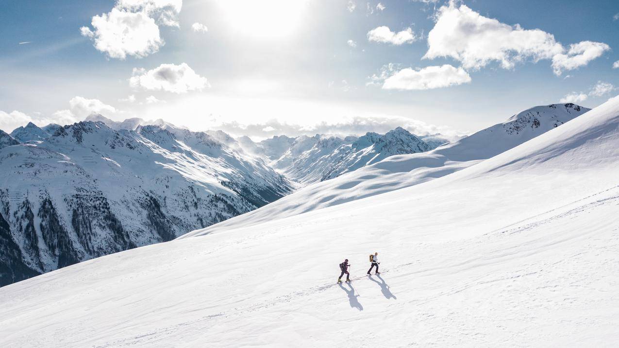 两个人在雪山上徒步旅行,4k风景高清壁纸